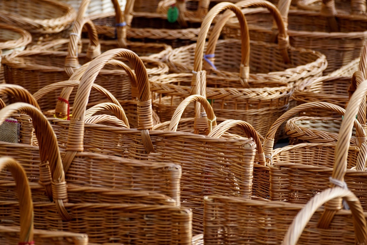 Many empty wicker baskets overlap in a dense display of handles, rims, and warm brown weave.